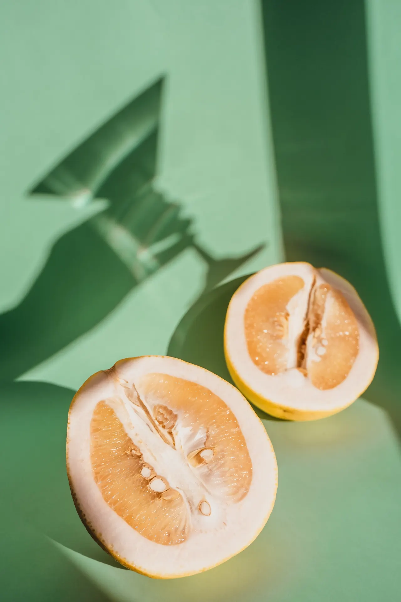 Fresh Pomelo Fruit on Green Background Wallpaper